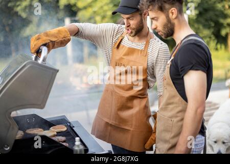 Two guys grilling at backyard Stock Photo