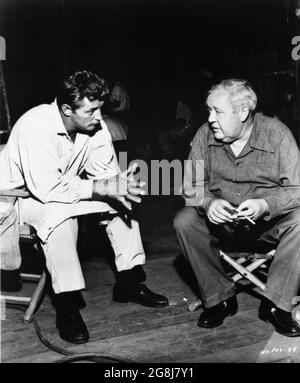 ROBERT MITCHUM and Director CHARLES LAUGHTON on set candid during filming of THE NIGHT OF THE HUNTER 1955 director CHARLES LAUGHTON novel Davis Grubb screenplay James Agate cinematographer Stanley Cortez music Walter Schumann art direction Hilyard M. Brown Paul Gregory Productions / United Artists Stock Photo