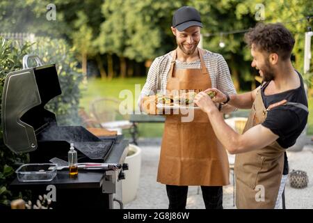 Two guys grilling at backyard Stock Photo