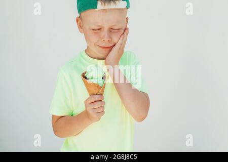 Portrait of a boy eating ice cream and felt toothache. dental care, health care concept Stock Photo