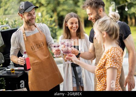 Friends celebrating with alcohol drinks outdoors Stock Photo