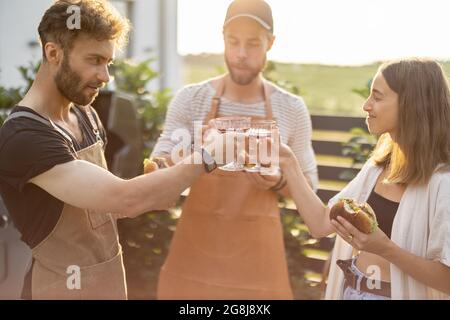 Friends celebrating with alcohol drinks outdoors Stock Photo