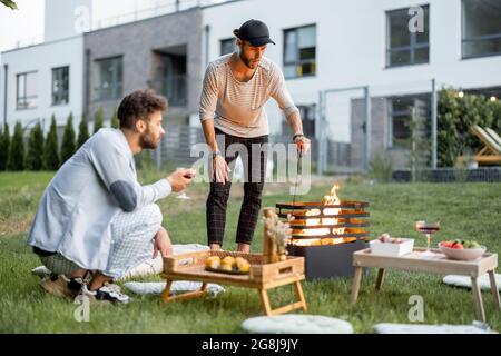 Friends have a picnic with barbeque at backyard Stock Photo
