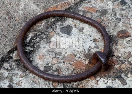 Old rusting steel mooring ring at a coastal harbour location Stock Photo