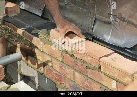 Close-up of bricks being layed during the construction of the external wall of a new bungalow in Surrey, UK Stock Photo