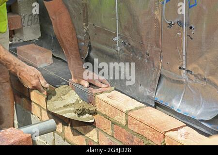 Close-up of bricks being layed during the construction of the external wall of a new bungalow in Surrey, UK Stock Photo