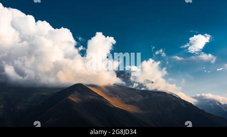 Thick clouds over the mountain peak Stock Photo