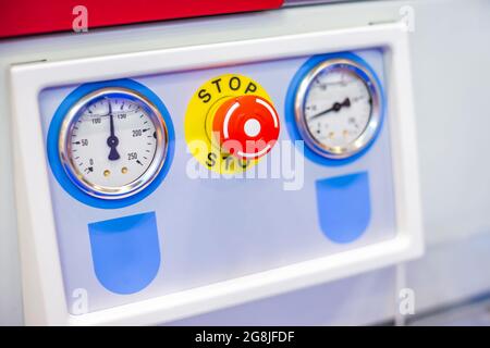Machine control panel with stop button and pressure gauge Stock Photo