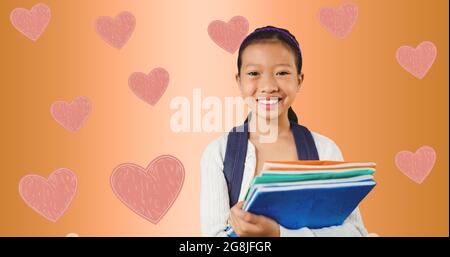 Composition of hearts over girl with notebooks Stock Photo