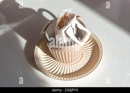 Coffee Drips in cup. Alternative brewing specialty coffee in paper filter bags. Stock Photo