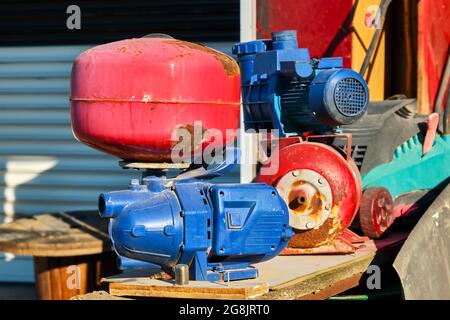 Old, rusty and worn centrifugal water pumps at the junkyard. Stock Photo