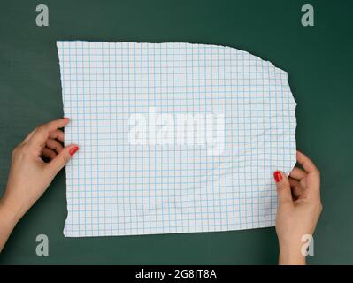 two female hands hold blank sheets of paper in a box, a place for an inscription Stock Photo