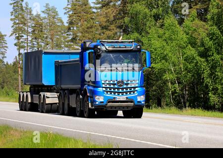 Blue Mercedes-Benz Arocs gravel truck and cassette trailer of Hänninen Group Oy on road in the summer. Raasepori, Finland. June 10, 2021. Stock Photo