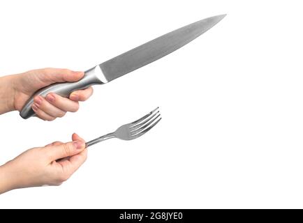 Kitchen utensil. Stainless steel knife and fork in woman hand, isolated on a white background Stock Photo