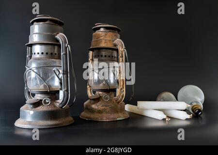 Old paraffin oil lamps, candles and incandescent light bulbs. Three 'old style' methods of providing light in the home. Stock Photo