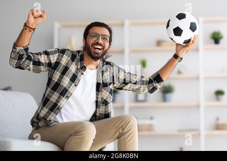 Emotional arab guy football fan watching game on TV Stock Photo