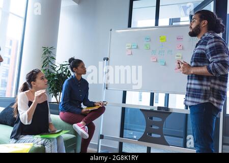 Diverse group of creative colleagues discussing work at meeting Stock Photo