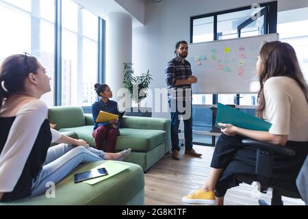 Diverse group of creative colleagues discussing work at meeting Stock Photo