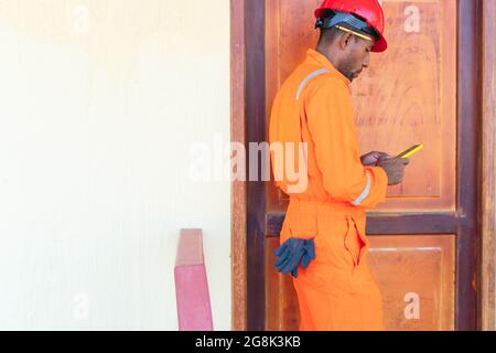 Professional technician is resting and using cell phone. Stock Photo