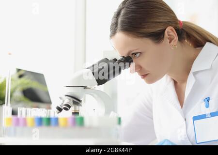 Adult caucasian beauty woman chemist looking at microscope Stock Photo