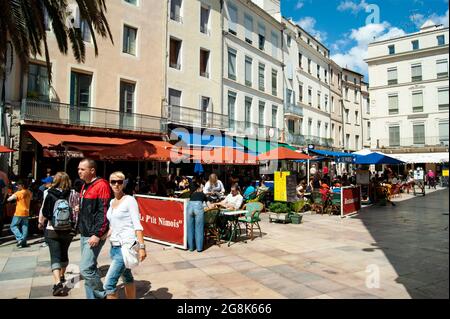 Nimes, France  Place de Marche Restaurants and pavement cafes line a colorful square in this historic southern French city People enjoy the scenery an Stock Photo