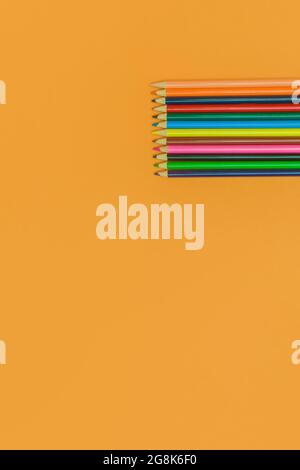 colored pencils on a yellow background Stock Photo