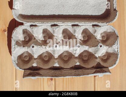 Grey egg carton without eggs on white background. egg carton box made from recycled paper with abstract repeated design pattern Stock Photo