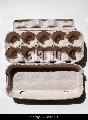 Grey egg carton without eggs on white background. egg carton box made from recycled paper with abstract repeated design pattern Stock Photo