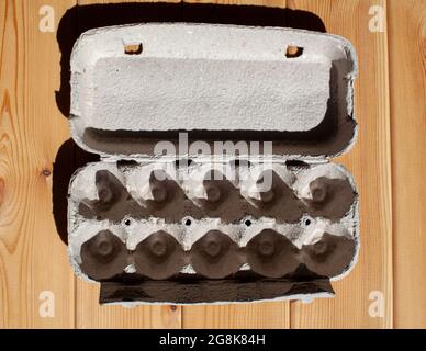 Grey egg carton without eggs on white background. egg carton box made from recycled paper with abstract repeated design pattern Stock Photo