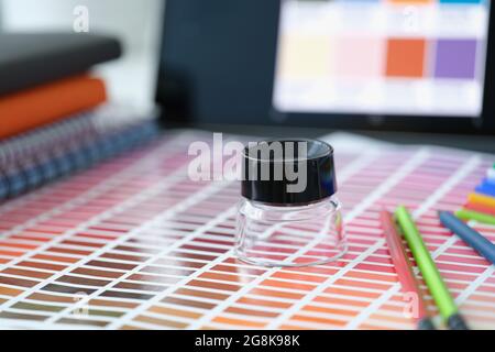 Multi-colored palette with different shades of colors with pencils and magnifying glass lie on table Stock Photo