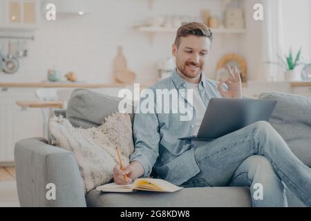 Young freelancer taking orders from client and writing them down Stock Photo