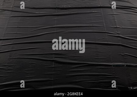 full frame abstract background of crumpled black plastic film bag. Stock Photo