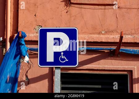 Metallic blue parking  sign for the handicapped people on the street Stock Photo