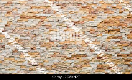 Abstract brown and white rock stone wall texture. Striped shadow and light on stone wall or stonework background. Home, Residential building. Stock Photo