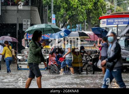 Manila, Philippines. 21st July, 2021. People wade through the flood brought by heavy monsoon rains in Manila, the Philippines, July 21, 2021. Credit: Rouelle Umali/Xinhua/Alamy Live News Stock Photo