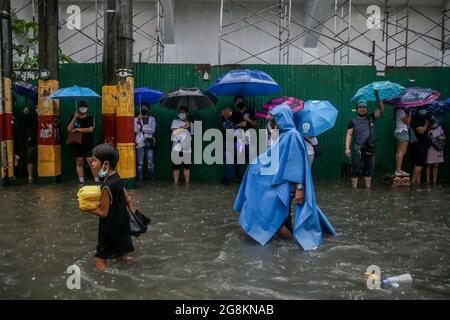 Manila, Philippines. 21st July, 2021. People wade through the flood brought by heavy monsoon rains in Manila, the Philippines, July 21, 2021. Credit: Rouelle Umali/Xinhua/Alamy Live News Stock Photo