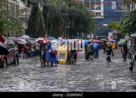 Manila, Philippines. 21st July, 2021. People wade through the flood brought by heavy monsoon rains in Manila, the Philippines, July 21, 2021. Credit: Rouelle Umali/Xinhua/Alamy Live News Stock Photo