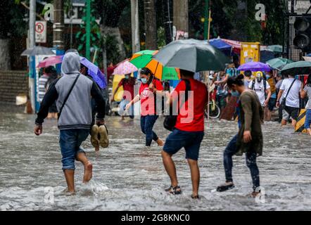 Manila, Philippines. 21st July, 2021. People wade through the flood brought by heavy monsoon rains in Manila, the Philippines, July 21, 2021. Credit: Rouelle Umali/Xinhua/Alamy Live News Stock Photo