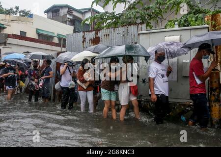 Manila, Philippines. 21st July, 2021. People wade through the flood brought by heavy monsoon rains in Manila, the Philippines, July 21, 2021. Credit: Rouelle Umali/Xinhua/Alamy Live News Stock Photo