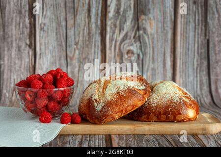 Closed up of white bun bread with fresh berries and jam for breakfast on wooden background Stock Photo