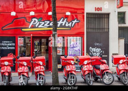 Row of red mopeds in front of a pizza store. Paris Stock Photo
