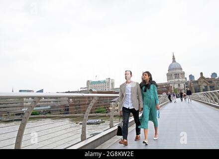 Asian couple holding hands walking on the Millennium Bridge towards the Tate Modern art gallery in summer 2021 during Covid London UK  KATHY DEWITT Stock Photo