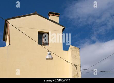 house facade with window and street lamp hanging on wire Stock Photo