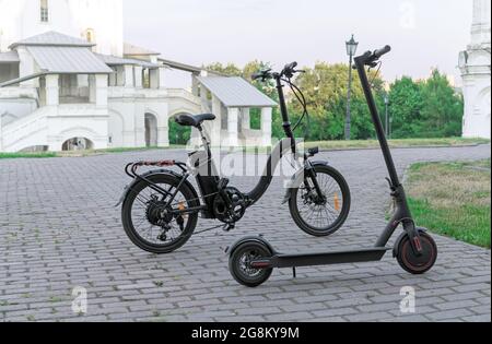 Electric bike and electric scooter on the background of an ancient building. Stock Photo