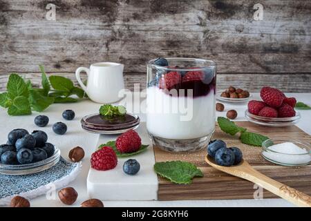 Preparation of fresh yoghurt with blueberries and raspberries Stock Photo