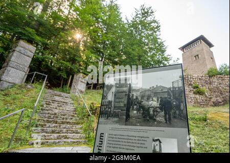 21 July 2021, Bavaria, Flossenbürg: An information board stands on the grounds of the Flossenbürg concentration camp memorial site in front of a former watchtower. Photo: Armin Weigel/dpa Stock Photo