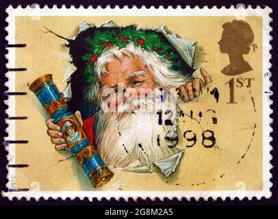 GREAT BRITAIN - CIRCA 1997: a stamp printed in Great Britain shows Santa bursting through wrapping paper with cracker, Christmas crackers, circa 1997 Stock Photo