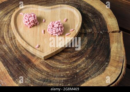 Two brigadiers of red fruits on a cracked wooden trunk board. Stock Photo