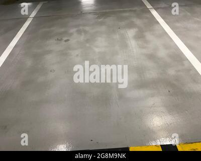 Basement car parking Single car lane separated by two white lines and Car stopper or bump to avoid entering into other car lane parking painted by usi Stock Photo