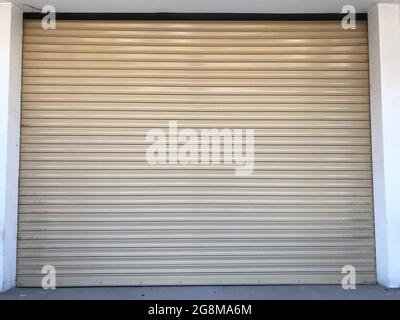 Beige color Mechanic or Hydraulic operated rolling shutter for an shop or garage or storage yard of an building and this is front entrance undulated s Stock Photo